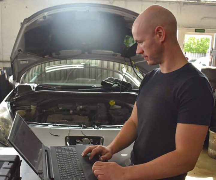 Monteur gebruikt laptop voor auto-diagnostiek in Autobedrijf Bos Hazerswoude.