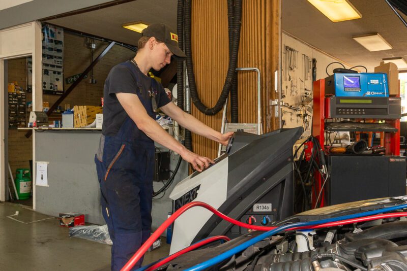 Autotechnicus Werkt Aan Voertuigdiagnostiek Monteur werkt aan auto-diagnostiek in moderne werkplaats.